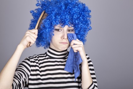 Portrait of sad girl with blue hair and comb. Studio shot.の写真素材