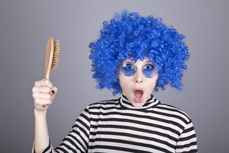 Surprised blue hair girl with comb. Studio shot.の写真素材