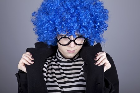 Funny fashion blue-hair girl in glasses and black coat. Studio shot.の写真素材