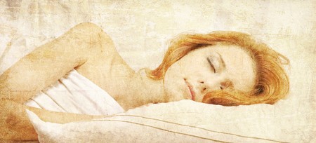 Pretty red-haired sleeping woman in white nightie lying in the bed. Photo in old retro style.の写真素材