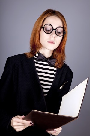 Portrait of beautiful and style red-haired girl with folder.の写真素材