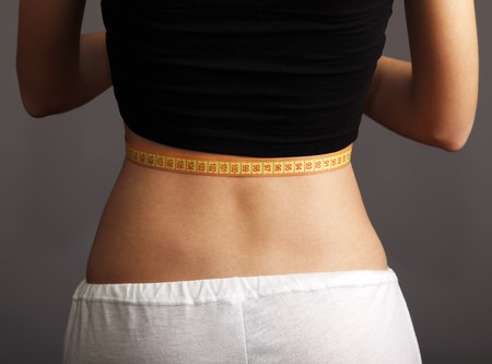 Beautiful and strong women's abs with metre. Studio shot. の写真素材