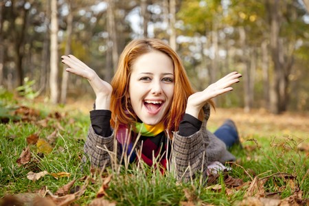 Portrait of red-haired girl in the autumn park. Outdoor shot.の写真素材