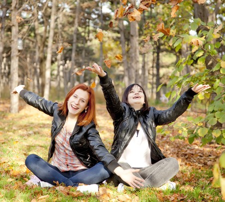 Two girlfriends at the autumn park. Outdoor shot.の写真素材