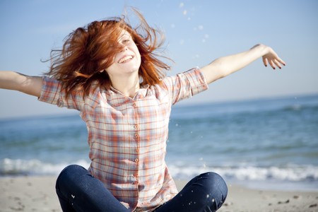Happy red-haired girl at the beach. Outdoor shot.の写真素材