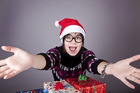 Funny girl in glasses with christmas gifts. Studio shot.