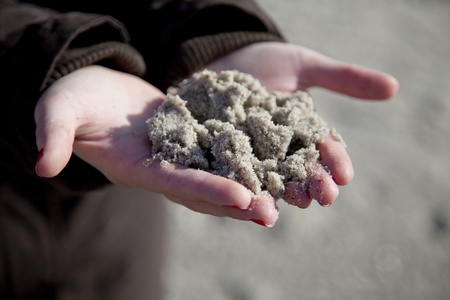 Wet sand in women hands.の写真素材