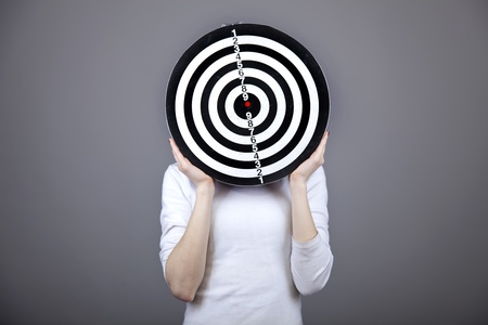 Girl with dartboard in place of head. Studio shot. の写真素材