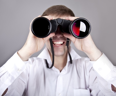 Young businessmen in t-shirt with black binocular. Studio shot.の写真素材