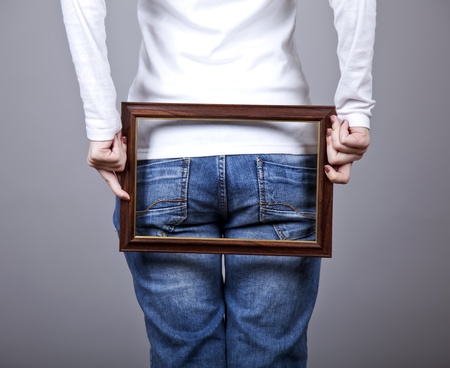 Girl keep frame over her ass. Studio shot.の写真素材