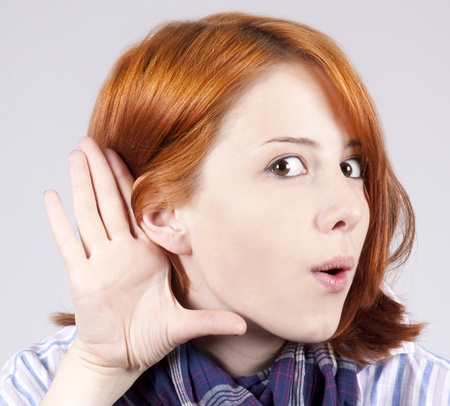 Redhead girl show her ear. 