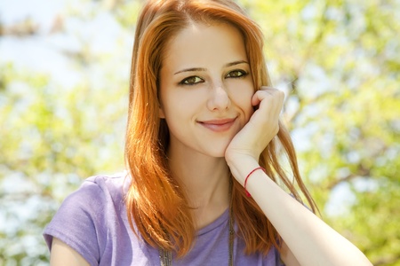 Beautiful redhead girl at the park in summer time. の写真素材