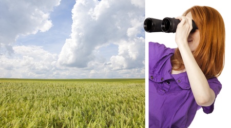 Teen redhead girl with binoculars looking at wheat field from corner.の写真素材