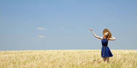 Redhead girl at spring wheat field.の写真素材