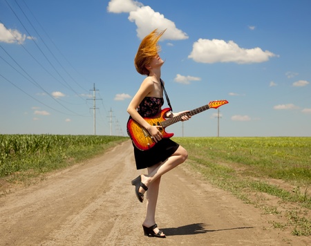 Rock girl with guitar at countryside.の写真素材