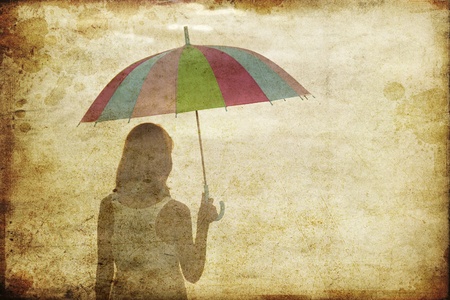 Girl with umbrella at sea coast. Photo in old image style.の写真素材