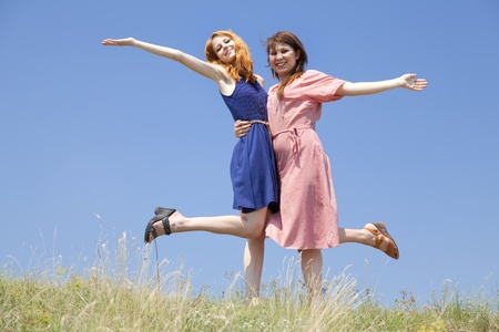 Two happy girls at meadow.の写真素材