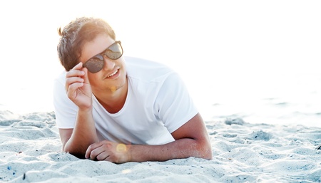 Beautiful brunette men at the beach in sunrise time.の写真素材