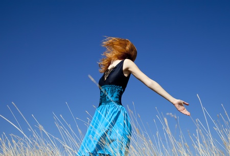Redhead girl at windy field.の写真素材