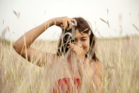 Brunette girl with camera at outdoor.の写真素材