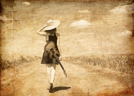 Rock girl with guitar at countryside. Photo in old image style.の写真素材
