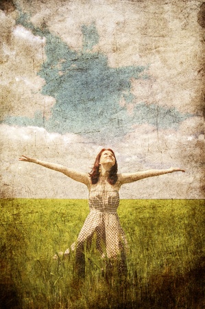 Beautiful young irl at green field.  Photo in old color image style.の写真素材