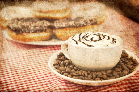 Donuts with coffee on table. Photo in old image style.の写真素材