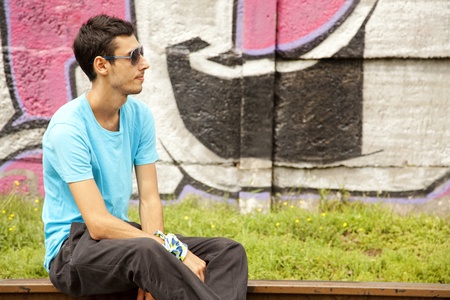 Young boy in glasses sitting at railway.の写真素材