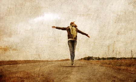 Redhead girl jumpig at outdoor. Autumn. Photo in old image style.の写真素材