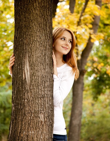 Portrait of red-haired girl in the autumn park. Outdoor shot.の写真素材