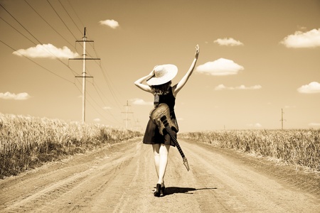 Rock girl with guitar at countryside. Photo in old yellow color image style.の写真素材