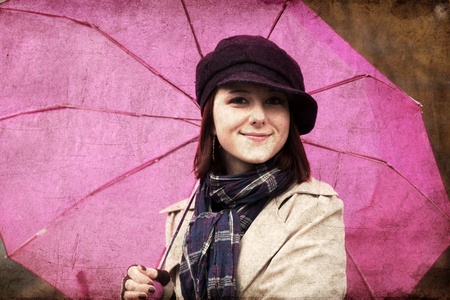 Girl in cloak and scarf with umbrella at park in rainy day. Photo in vintage style with nature colour.の写真素材