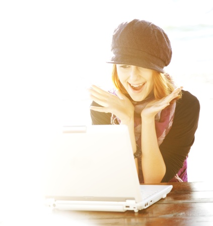 Portrait of red-haired girl with laptop and backside light.の写真素材