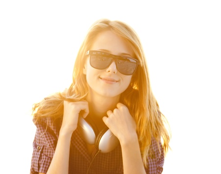 Red-head girl with headphones at the beach in sunrise.の写真素材