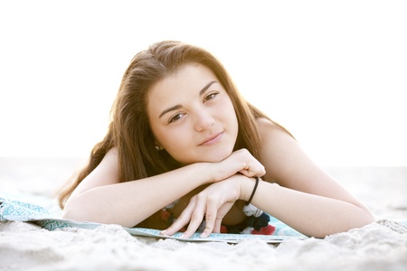 Brunette girl at the beach in sunrise.の写真素材