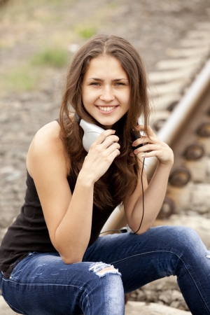Teen girl with headphones at railways.の写真素材