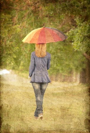 Young fashion girl with umbrella at spring outdoor. Photo in old image style.の写真素材