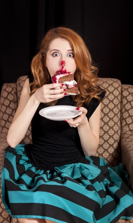 Redhead girl secretly eating cake.の写真素材