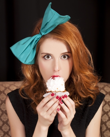 Redhead girl secretly eating cake.の写真素材