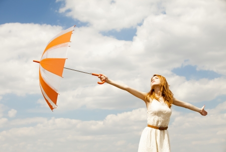 Girl with umbrella at sky background.の写真素材