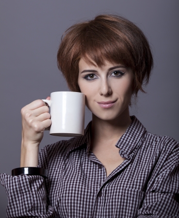 Style girl in shirt with cup at studio.の写真素材