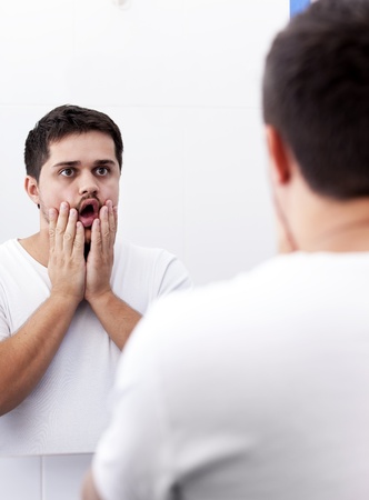 Surprised men near mirror.の写真素材