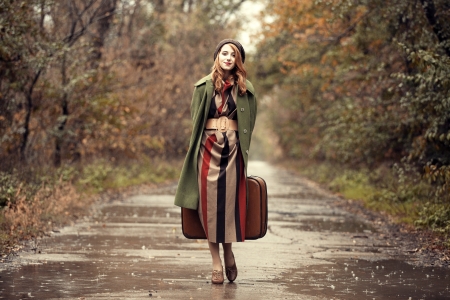Style redhead girl with suitcase at beautiful autumn alley.の写真素材
