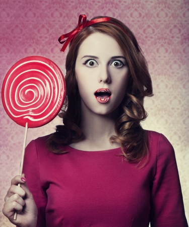 Beautiful redhead girl with lollipop. の写真素材