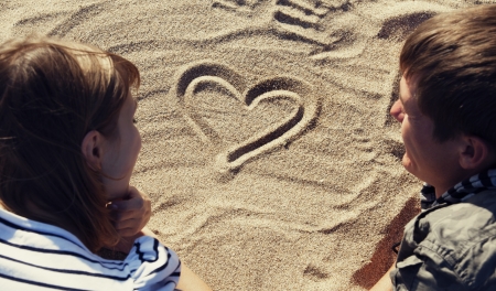 People drawing heart at sand.の写真素材