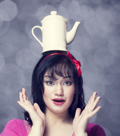 Brunette women with teapot on head.の写真素材
