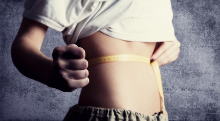 Beautiful and strong women's abs with metre. Studio shot.の写真素材