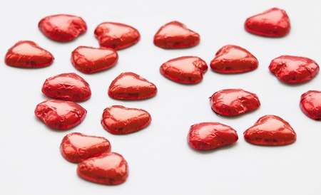 Red chocolate hearts candies on whiteの写真素材