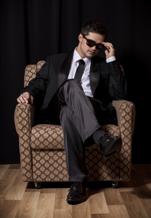 Man with cigarette sitting in vintage armchairの写真素材