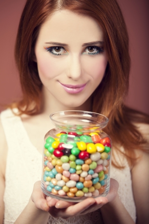 young woman holding a bowl full of jelly beans の写真素材